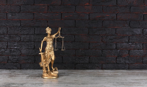 golden figurine of Themis on a black background