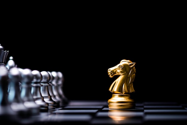 Golden horse chess encounters with silver chess enemy on chess board and black background.