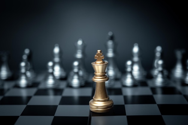 Golden King chess standing in front on board game Concept leadership strategy business