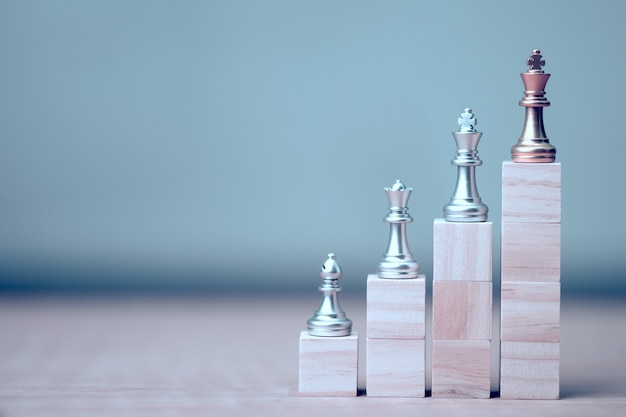 Golden king chess at winner position on wooden cube of the chess game