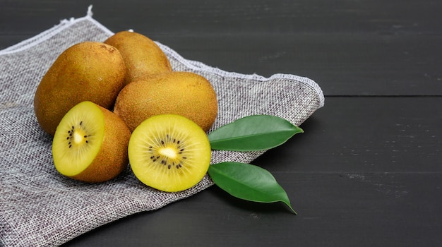 Golden kiwi on a black wooden table.