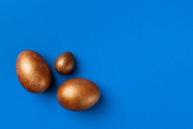 Golden modern easter eggs isolated on blue