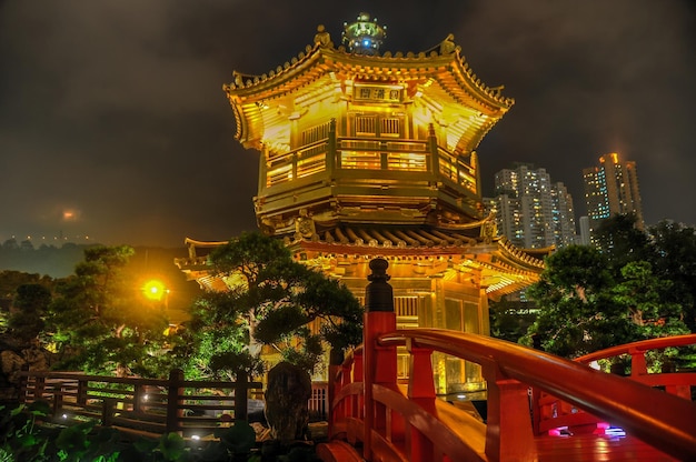 Photo the golden pavilion and red bridge in the nan lian garden near the chi lin nunnery a famous landmark in hong kong