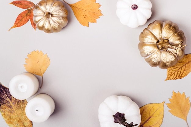 Golden pumpkin and candle frame on gray background Autumn Holiday concept