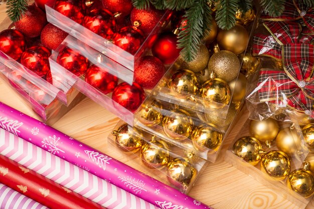 Golden and red Christmas bulbs wrapping paper bows on wooden background Preparing christmas decorations winder holidays season