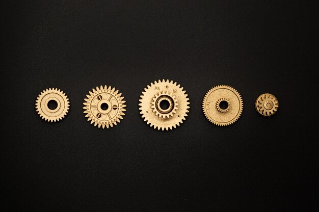 Photo golden round gears on black surface photo