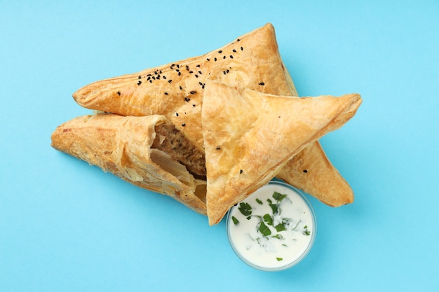 Golden samsa with ingredients on blue background