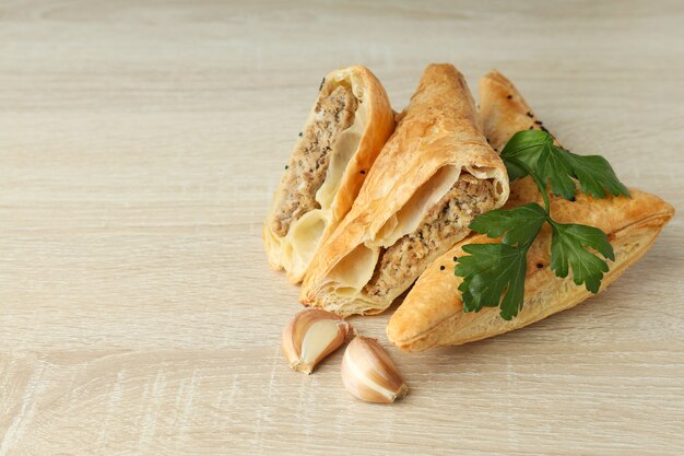 Golden samsa with ingredients on wooden background