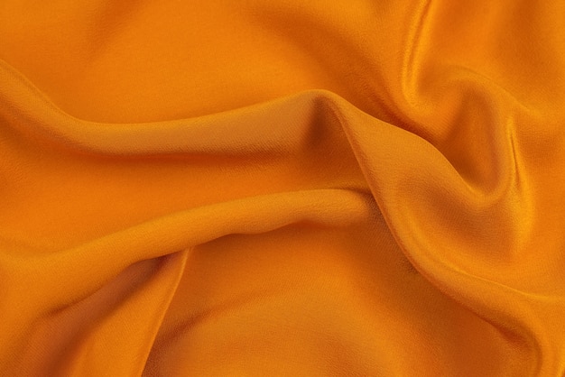 Golden silk or satin luxury fabric texture can use as abstract.