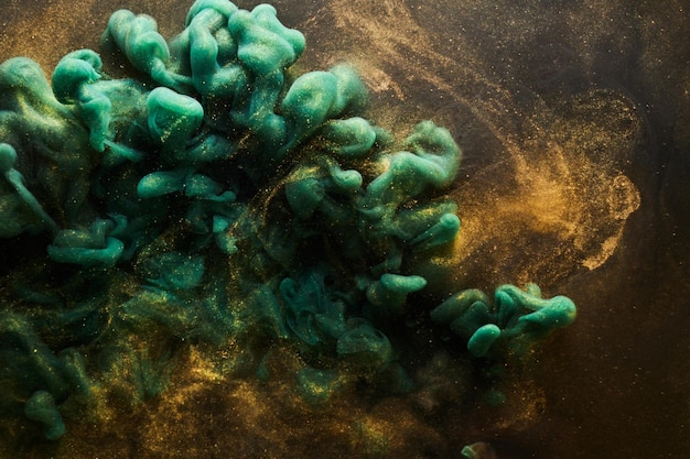 Golden sparkling abstract background luxury green smoke acrylic paint underwater explosion cosmic swirling ink