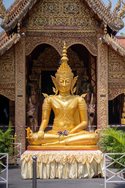 Photo a golden statue of a buddha sits in a temple.