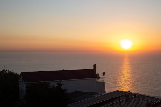 Golden sunrise sunset over the sea near port and city