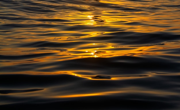 Golden texture of sea waves during sunset