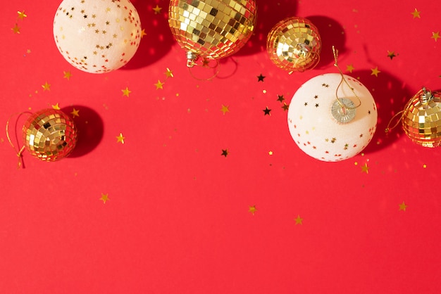 golden and white christmas balls with shiny stars on red background