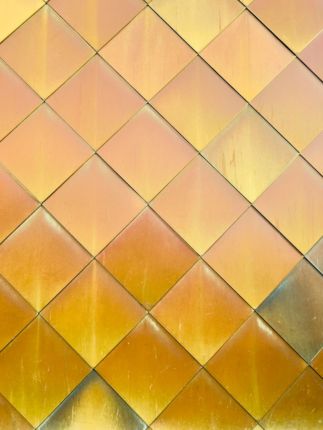 Golden yellow brass tiles wall background.