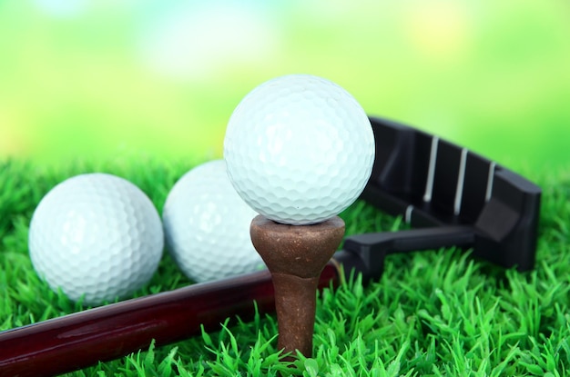 Golf ball and driver on green grass outdoor close up