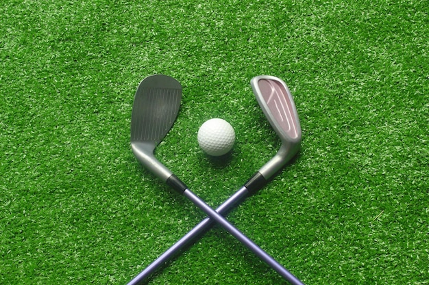 Golf balls and golf clubs on green grassGolf equipment in the top viewSports that people around the world play during the holidays for health