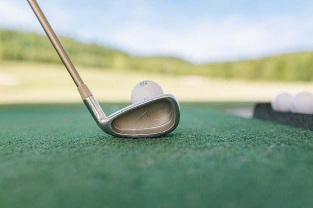 Golf club and ball in grass. Buttom view