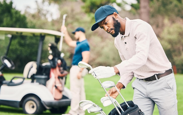 Photo golf club and black man choose on course with golfing bag ready to start game practice and training professional golfer activity and male caddy with choice for exercise fitness and recreation