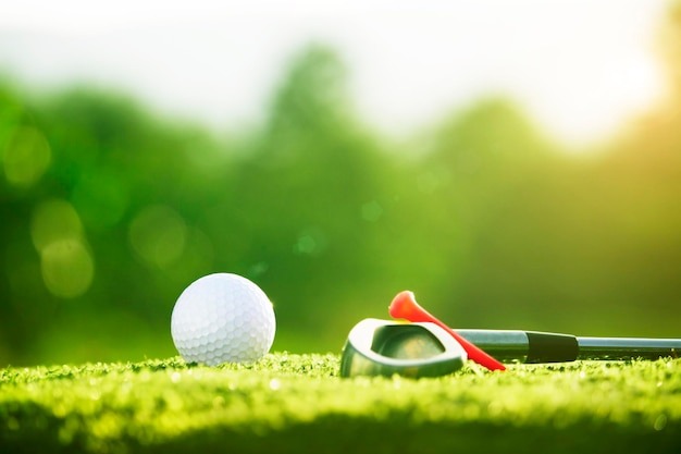 Golf clubs and golf balls on a green lawn in a beautiful golf course