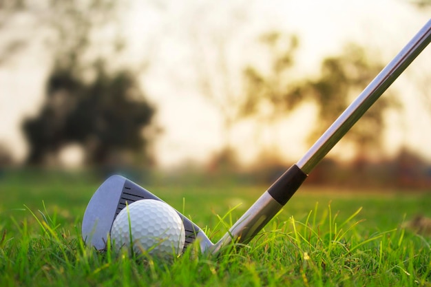 Golf clubs and golf balls on a green lawn in a beautiful golf course