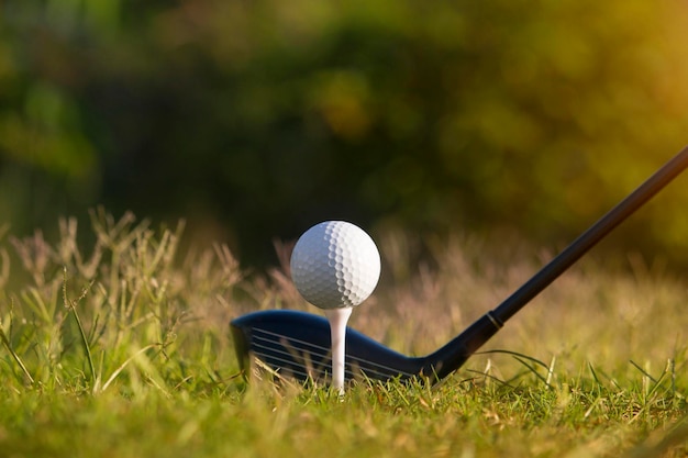 Golf clubs and golf balls on a green lawn in a beautiful golf course