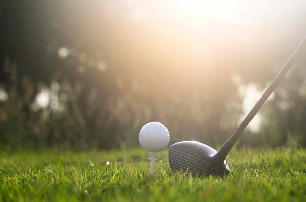 Golf clubs and golf balls on a green lawn in a beautiful golf course