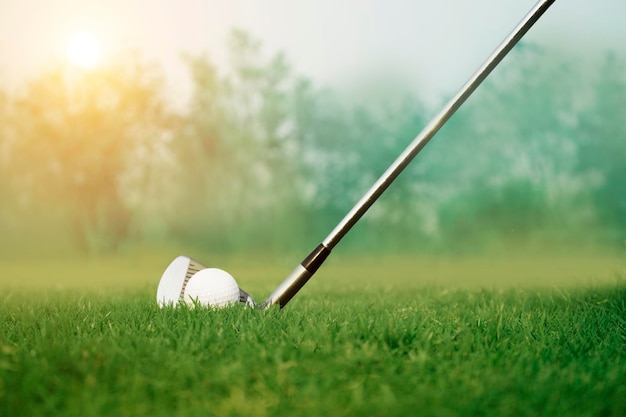 Golf clubs and golf balls on a green lawn in a beautiful golf course