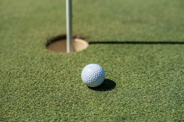 Golf field with white ball near the hole