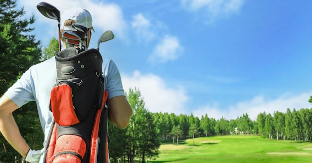 Golf player walking and carrying bag on course during summer game golfing