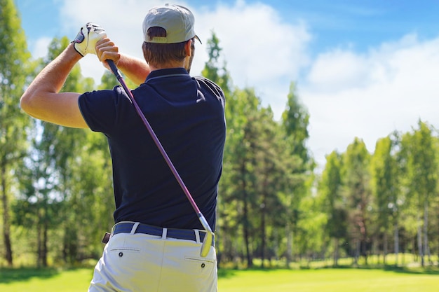 Golfer hits an fairway shot towards the club house