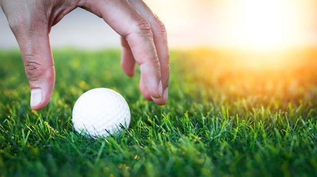 Golfer's hand holds golf ball close up on tee grass on blurred beautiful landscape of green background Concept international sport that rely on precision skills for health relaxationx9