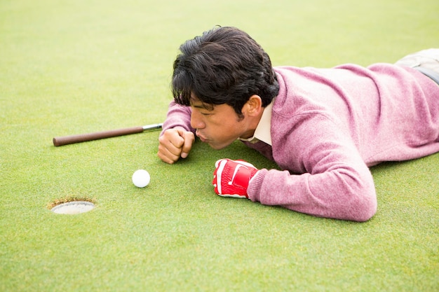 Golfer trying to flick ball into hole