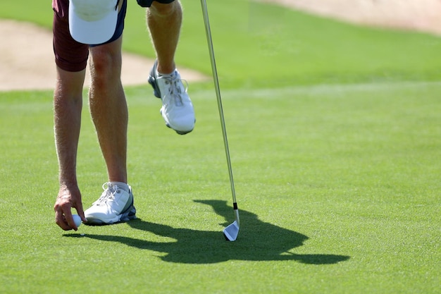 Golfers hand placing golf ball onto tee close up