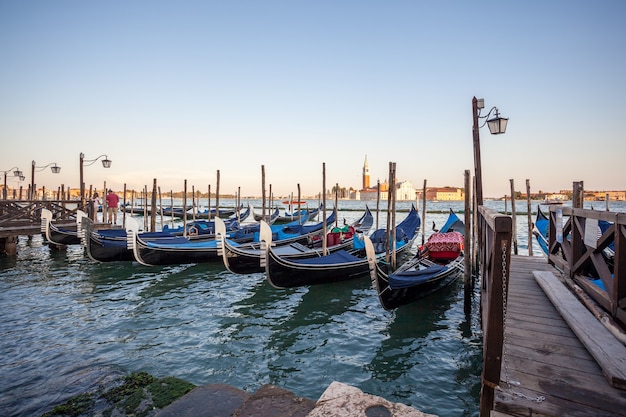 Gondolas moored by Saint Mark square with San Giorgio di Maggiore church