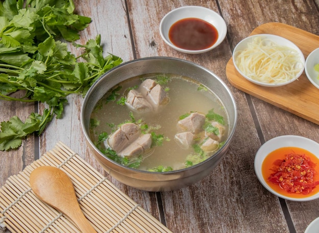 Gongwan soup or Gong wan pork balls meat soup with chilli sauce noodles spoon and chopsticks served in bowl isolated on napkin top view of hong kong food