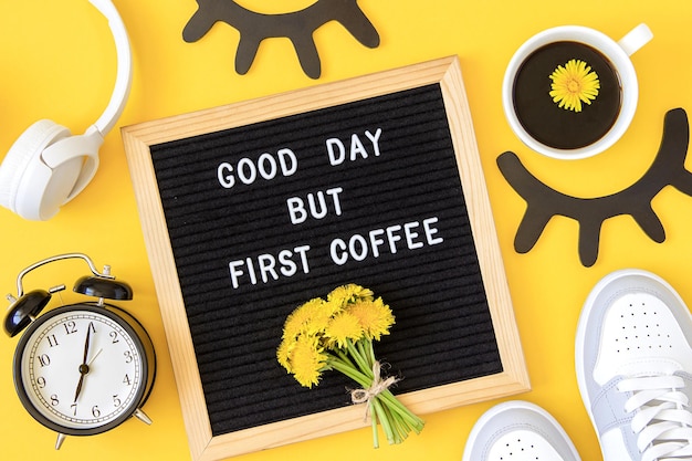 Good day but first coffee Motivational quote on letter board bouquet yellow flowers and cup of coffee on yellow background Concept inspirational quote of the day