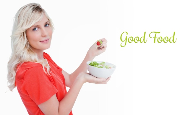 Good food against side view of a young blonde woman eating vegetable salad