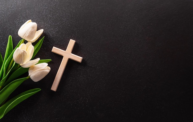 Good Friday and Holy week concept A religious cross and flower on dark stone background