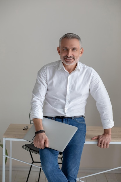 Good-looking gray-haired man working on laptop