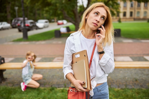 good looking woman talking on mobile phone while thinking about something important from work