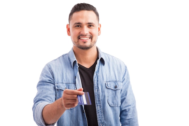 Good looking young man with a beard paying with his credit card against a white background