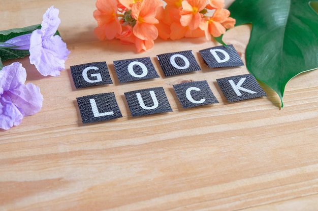 Photo good luck tag with flower on wood table