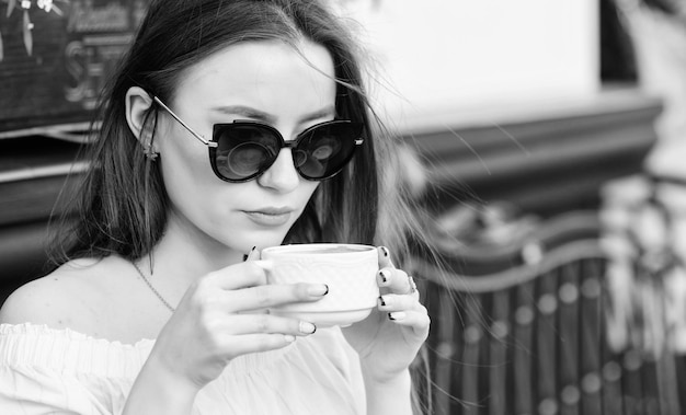 Good morning Breakfast time stylish woman in glasses drink coffee girl relax in cafe Business lunch morning coffee Waiting for date summer fashion Meeting in cafe Her perfect breakfast