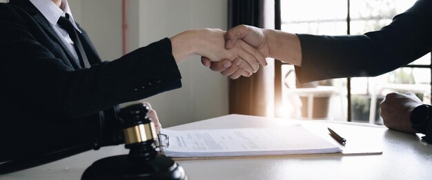 Good service cooperation of Consultation between a male lawyer and business woman customer Handshake after good deal agreement Law and Legal concept