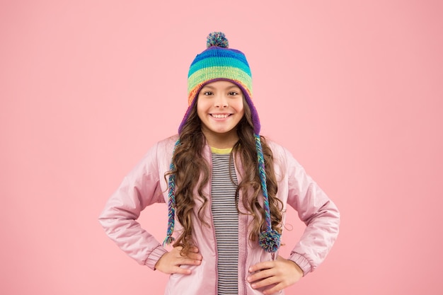 Good time small girl winter hat warm clothes for cold season cheerful child pink background kid fashion and shopping trendy girl smiling ready for winter activity autumn style happy childhood