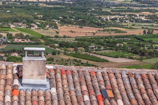 Gordes village and view of Luberon valley with fields green trees and farms Vaucluse Provence