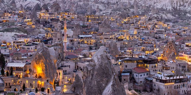 Goreme City at twilight Famous tourist center of balloon fligths in Cappadocia Turkiye Aerial view twilight Goreme City from the mountain Night view of Goreme Cappadocia Turkey