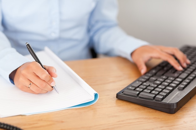 gorgeous businesswoman typing and writing 