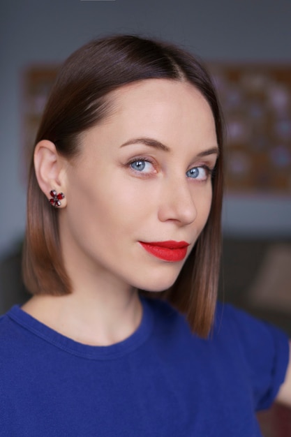 Gorgeous close up portrait of caucasian woman with blue eyes, white sking and red lips, natural hair